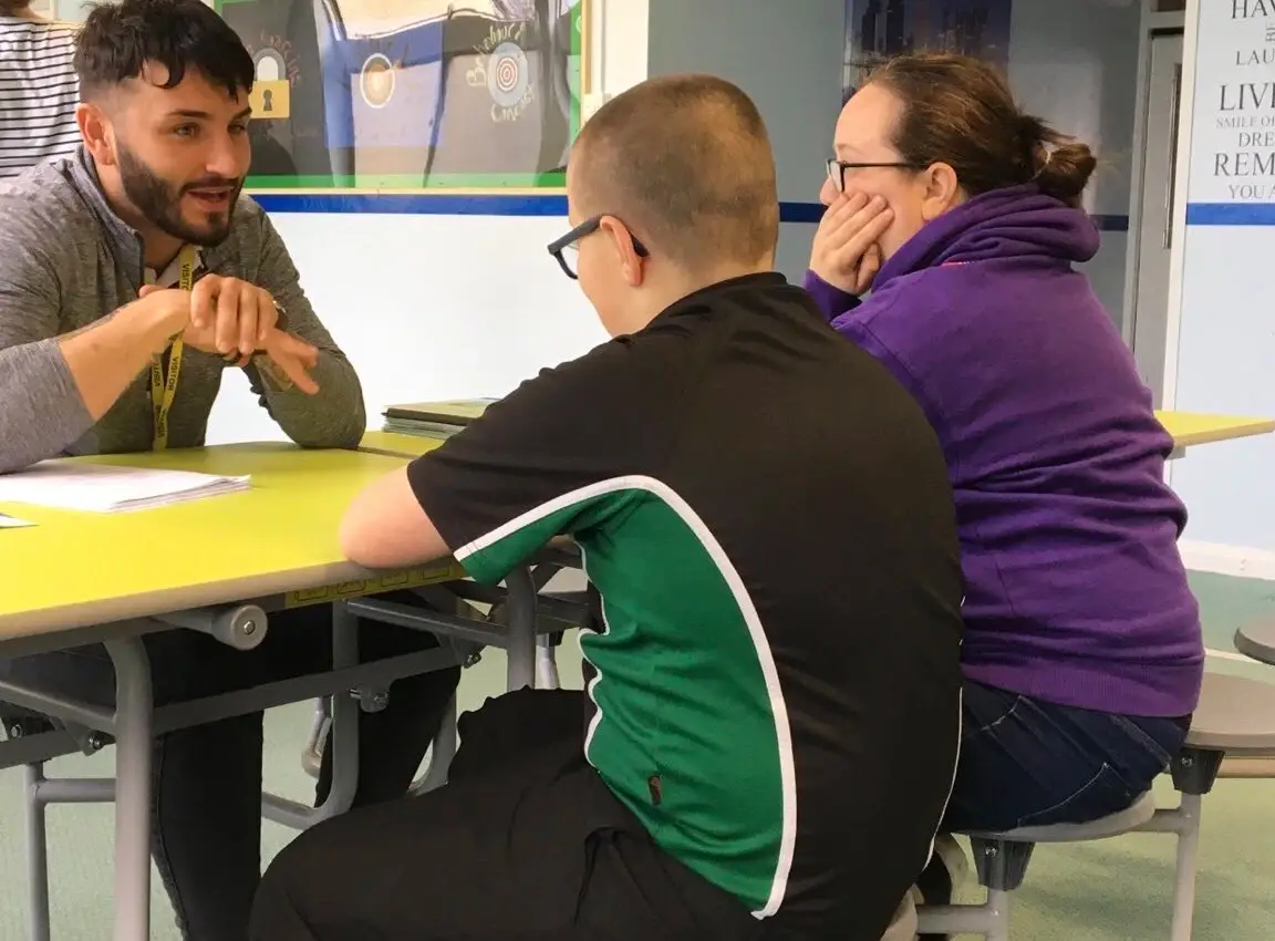 Tom Hoskins of Chance is Change talking to a parent and child during a mentoring session